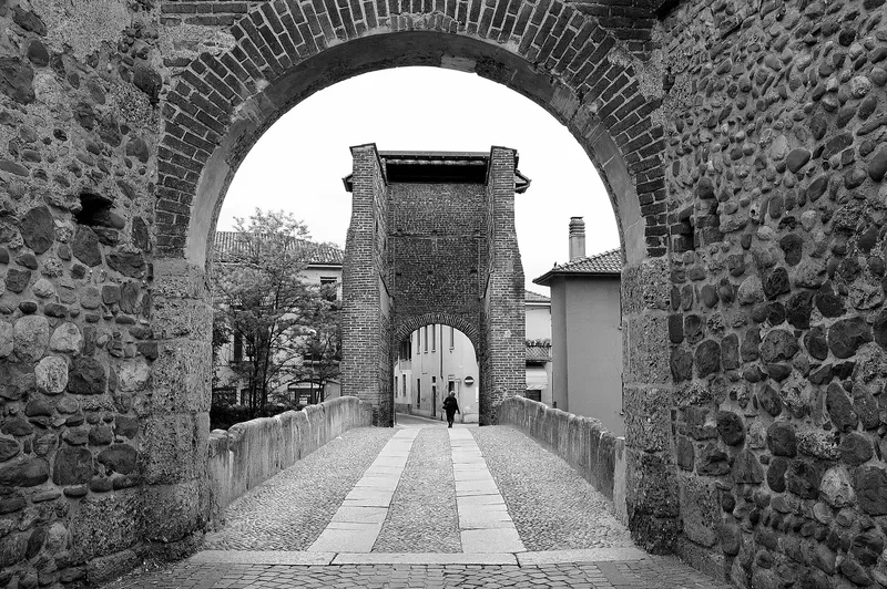 Il Ponte di San Rocco visto attraverso l’arco in pietra e mattoni della torre, in bianco e nero