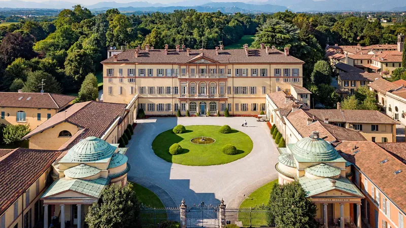 Villa Gallarati Scotti a Oreno dall’alto: il palazzo giallo, la corte d’onore con il prato ovale e i due padiglioni con le cupole verdi